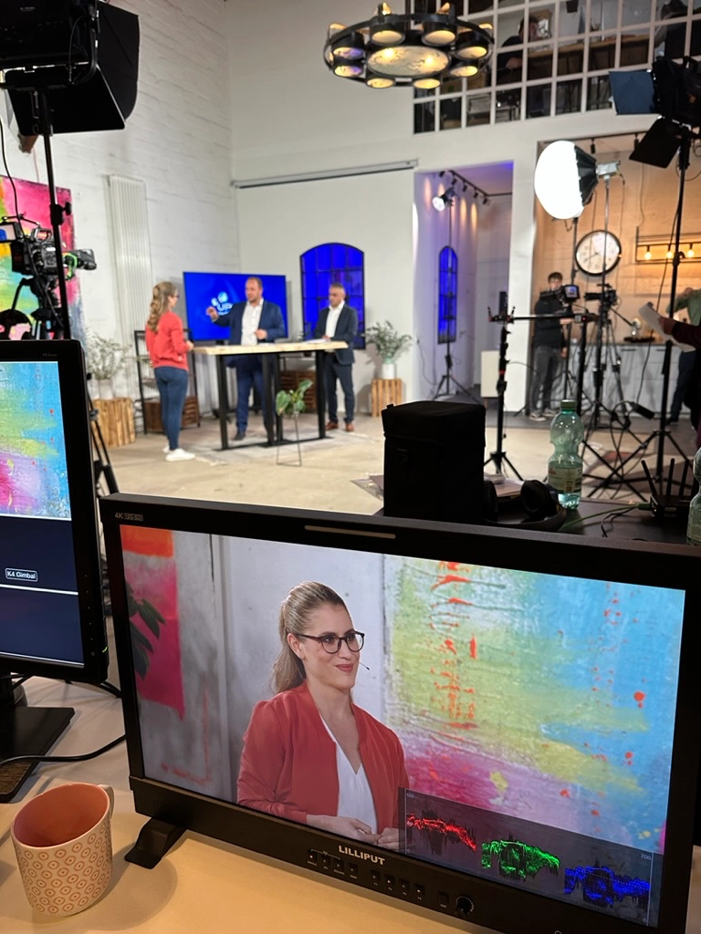TV Studio mit der Moderatorin für Nachhaltigkeit Janine Utsch bei der Moderation eines Expertengesprächs zum klimaneutralen Gebäudebestand 2025 von Brunata Metrona