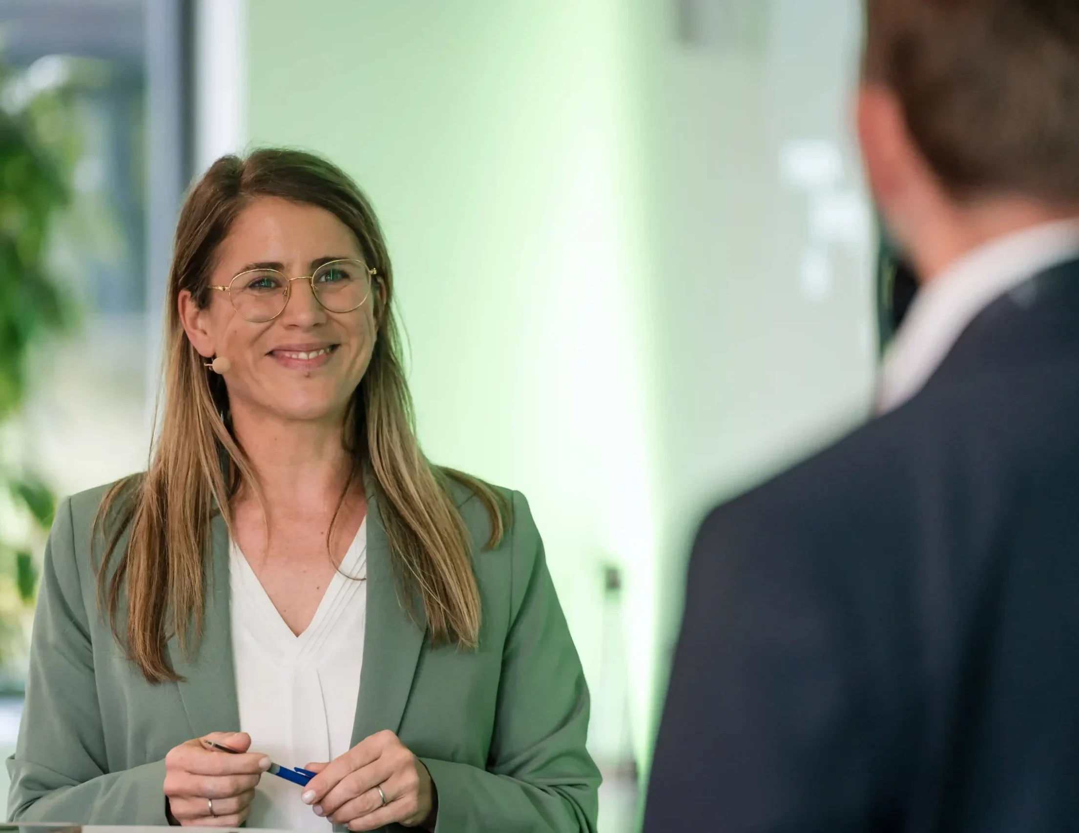 Portrait der Moderatorin für Bauwirtschaft und Immobilien Janine Utsch mit grünem Blazer