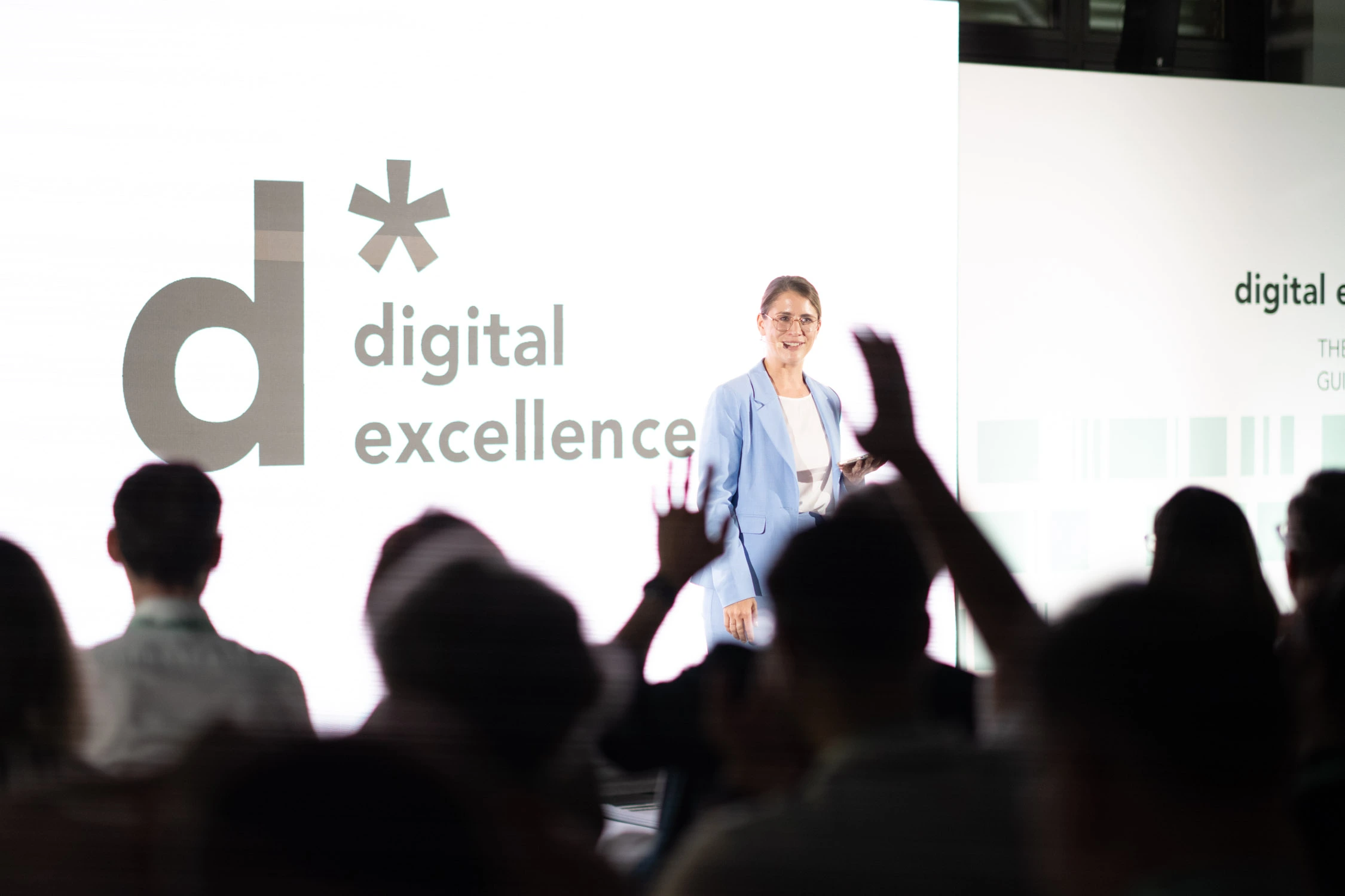 Moderatorin in Frankfurt: Janine Utsch auf der Bühne bei der Digital Excellence, im Vordergrund begeistertes Publikum